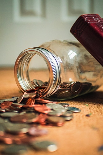 A jar full of coins on a table.