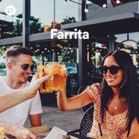 A man and woman are sitting at a table with a drink in their hands.