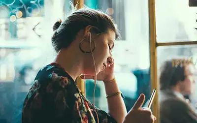 woman listening to music through headphones