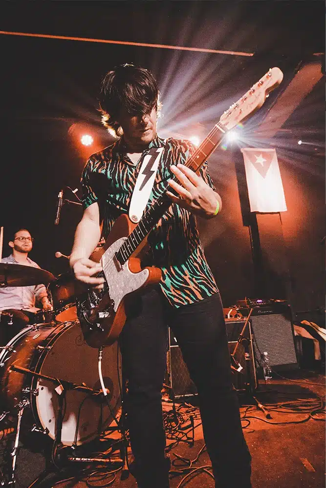 A man playing a guitar on a stage.