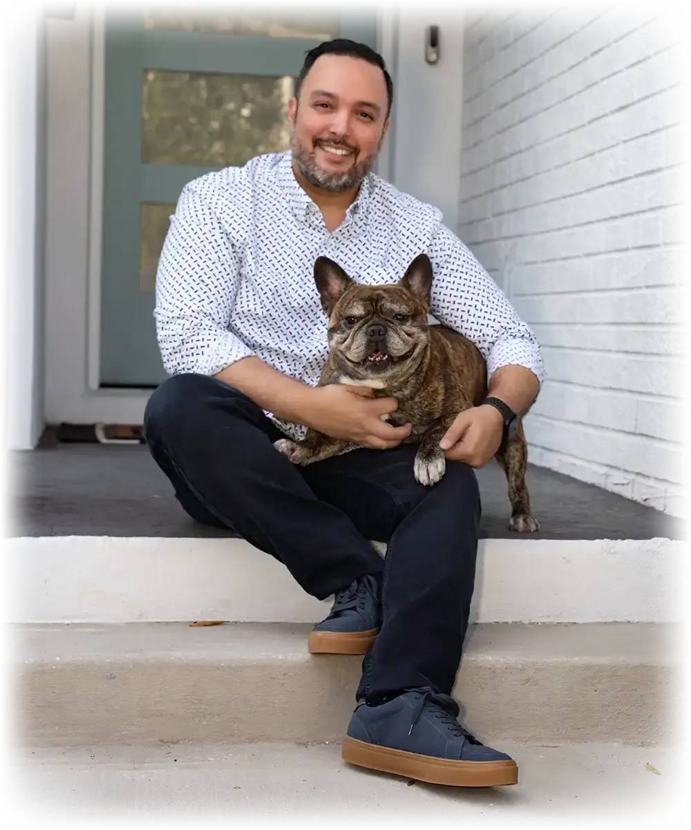 A man sitting on the steps of a house with a dog.